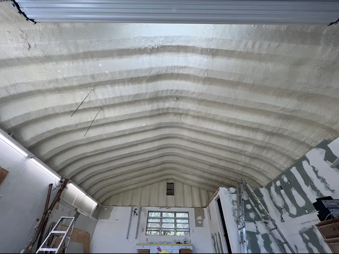 Spray polyurethane foam applied to the underside of a metal roof deck in Forney